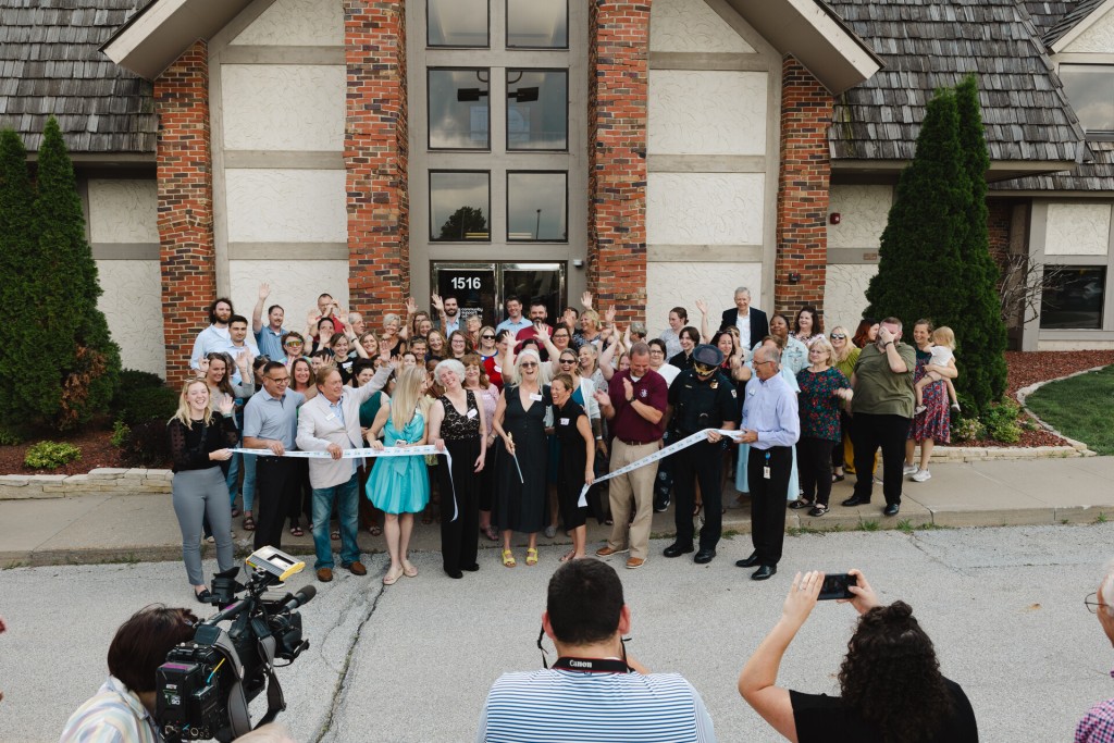 Team CSA's grand opening celebration. Image depicts CSA staff cutting a ribbon with numerous people in celebration.